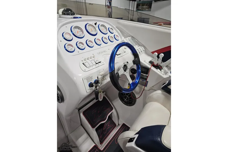 Slide: The Image of 2000 Donzi 33 ZX boat cockpit with blue steering wheel and detailed instrument panel. - 51