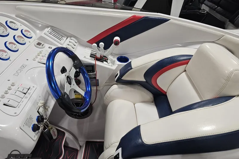 Slide: The Image of Interior of a 2000 Donzi 33 ZX boat with blue steering wheel and white leather seats. - 52