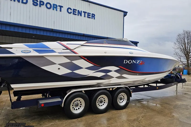 Slide: The Image of 2000 Donzi 33 ZX speedboat with checkered design on trailer at sport center. - 6