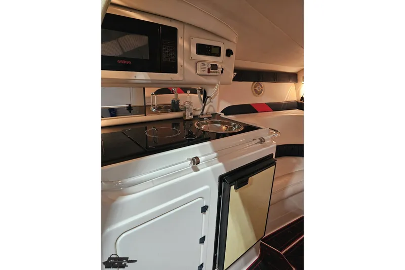 Slide: The Image of 2000 Donzi 33 ZX cabin interior with kitchenette, microwave, and seating area. - 60