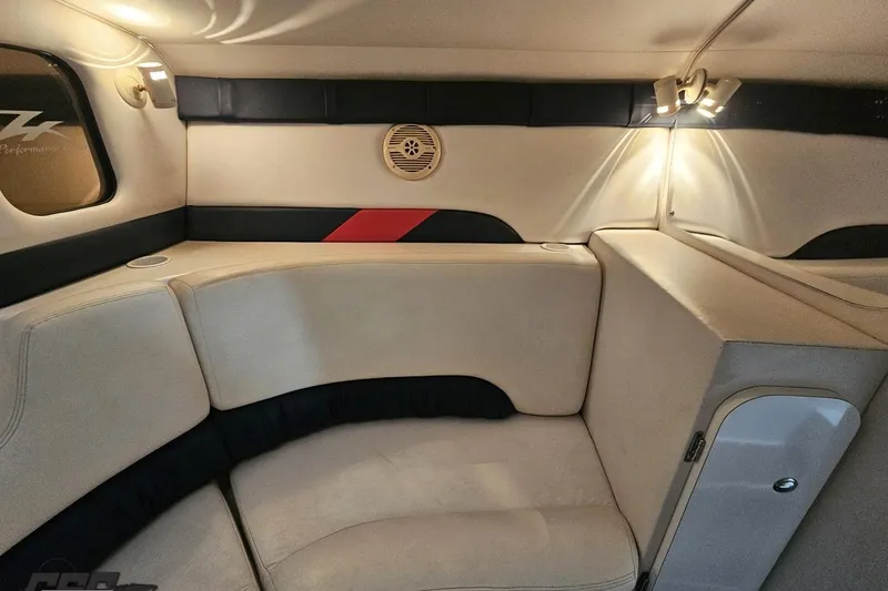 Slide: The Image of Interior of a 2000 Donzi 33 ZX boat, featuring beige seating and ambient lighting. - 63