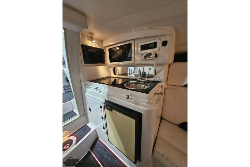 Slide: The Image of Interior of 2000 Donzi 33 ZX boat featuring kitchenette with sink, microwave, and storage. - 68