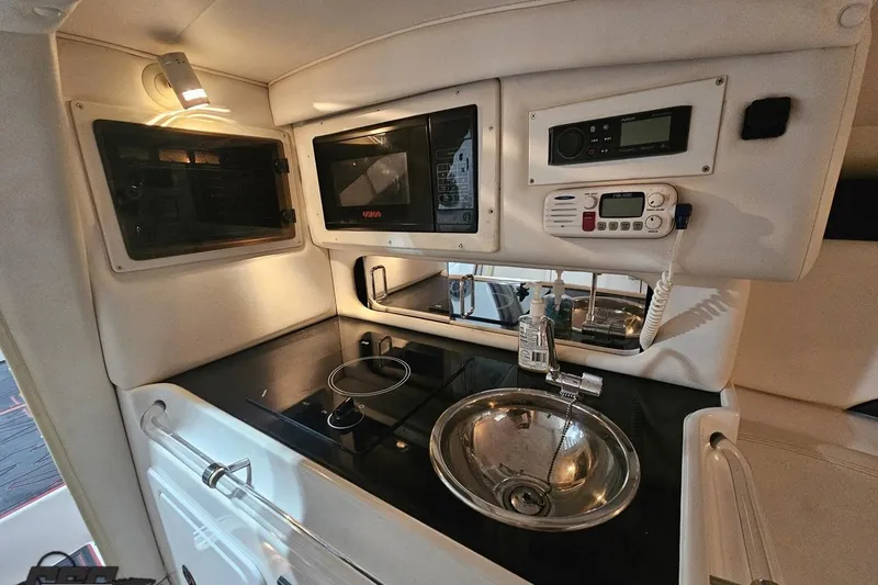 Slide: The Image of Interior of 2000 Donzi 33 ZX boat featuring kitchen amenities and control panel. - 69
