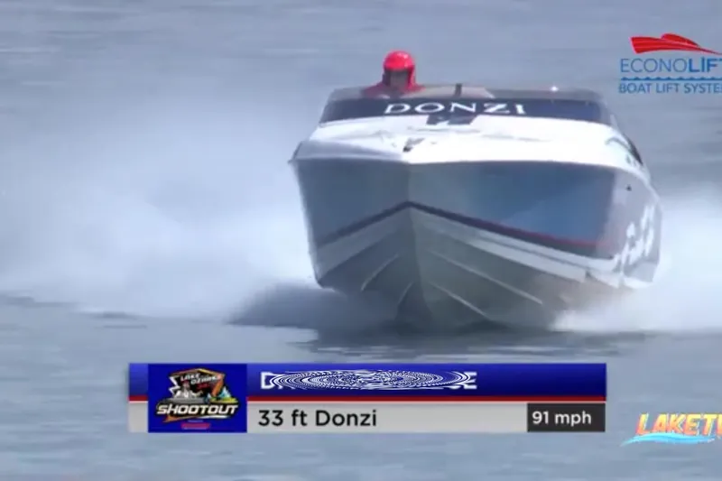 Slide: The Image of 2000 Donzi 33 ZX speedboat racing at 91 mph on water, featuring bold branding. - 94