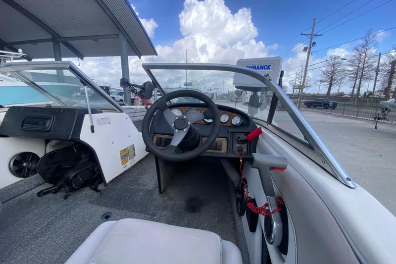 Slide: The Image of 2002 Skeeter SL 190 boat interior with steering wheel and dashboard, under a cloudy sky. - 15