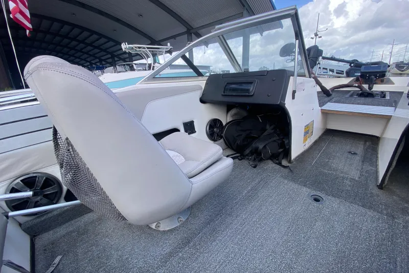 Slide: The Image of 2002 Skeeter SL 190 boat interior with seating and dashboard, under a covered dock. - 16