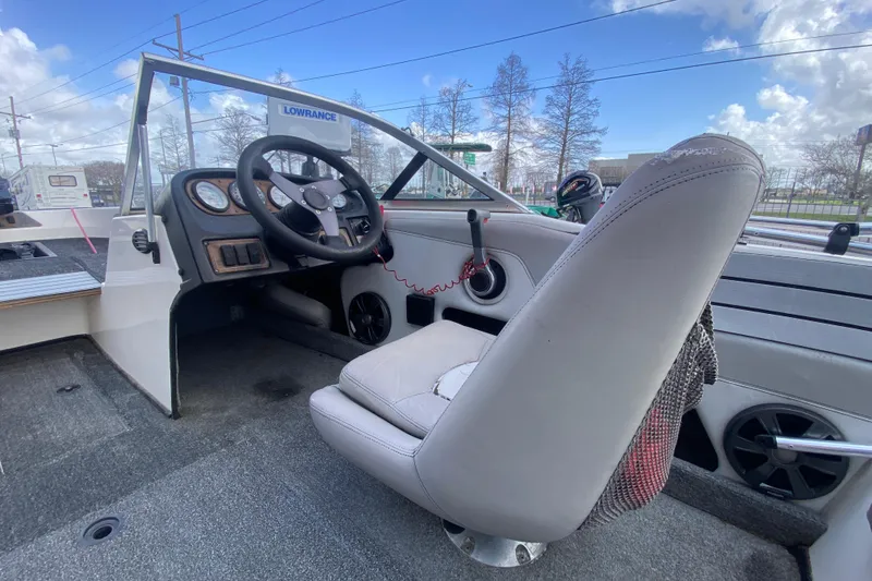 Slide: The Image of 2002 Skeeter SL 190 boat interior with steering wheel, dashboard, and seating under a blue sky. - 17