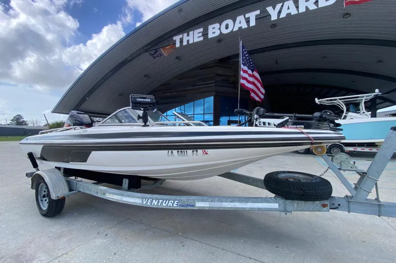 Slide: The Image of 2002 Skeeter SL 190 boat on trailer at The Boat Yard, American flag in background. - 2