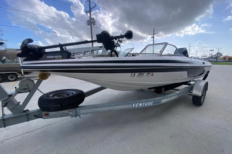 Slide: The Image of 2002 Skeeter SL 190 boat on trailer with Minn Kota motor, under cloudy sky. - 8
