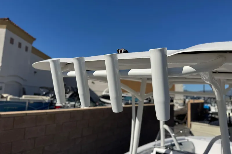 Slide: The Image of 2024 Aquasport 2200 Center Console boat with rod holders, outdoor setting. - 18