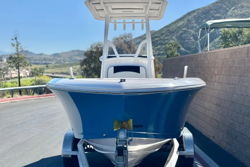 Slide: The Image of 2024 Aquasport 2200 Center Console boat on trailer, scenic mountain backdrop. - 2