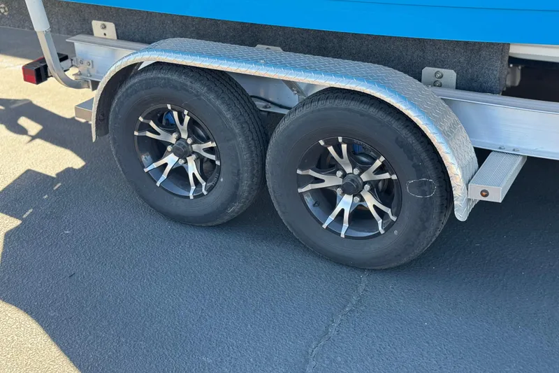 Slide: The Image of Trailer wheels of 2024 Aquasport 2200 Center Console boat on pavement. - 33