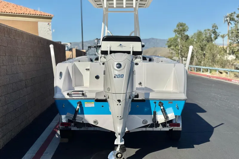 Slide: The Image of 2024 Aquasport 2200 Center Console boat with powerful outboard motor, parked outdoors. - 4