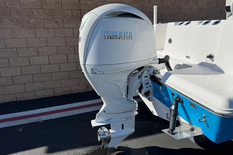 Slide: The Image of 2024 Aquasport 2200 Center Console with Yamaha outboard motor, parked on pavement. - 6