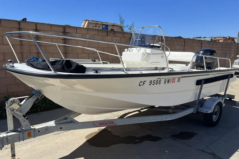 Slide: The Image of 2016 Boston Whaler 170 Montauk boat on trailer, parked outdoors. - 1