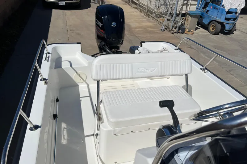 Slide: The Image of 2016 Boston Whaler 170 Montauk boat interior with seating and Mercury outboard motor. - 11