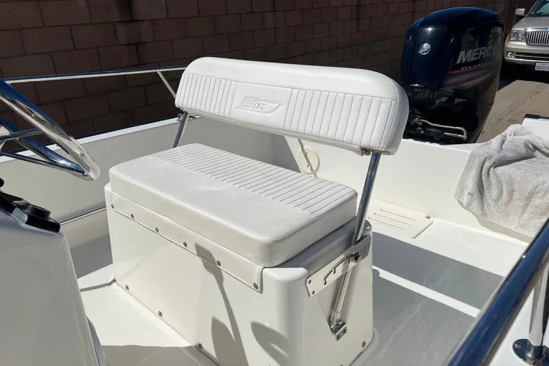 Slide: The Image of 2016 Boston Whaler 170 Montauk boat interior with white seating and Mercury engine. - 5