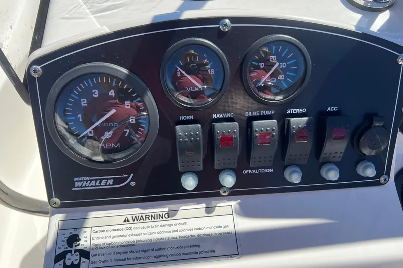 Slide: The Image of Dashboard of a 2016 Boston Whaler 170 Montauk boat with gauges and switches. - 9