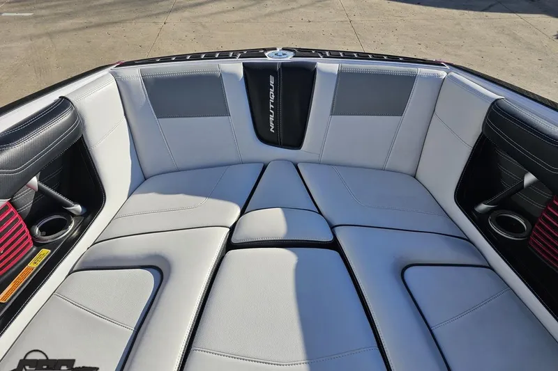 Slide: The Image of Luxurious seating in 2015 Nautique Super Air Nautique G23 boat, featuring sleek design and cup holders. - 101