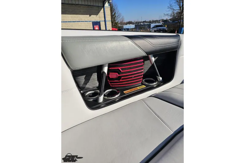 Slide: The Image of 2015 Nautique Super Air Nautique G23 interior with cup holders and storage compartment. - 104