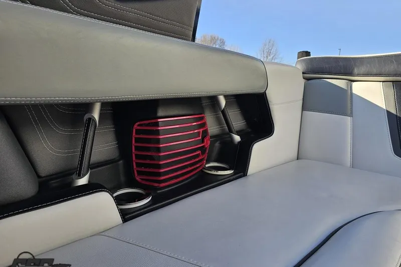 Slide: The Image of 2015 Nautique Super Air Nautique G23 interior seating with cup holders and red accent. - 112