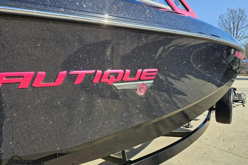 Slide: The Image of 2015 Nautique Super Air Nautique G23 boat with sparkling black finish and pink logo. - 12