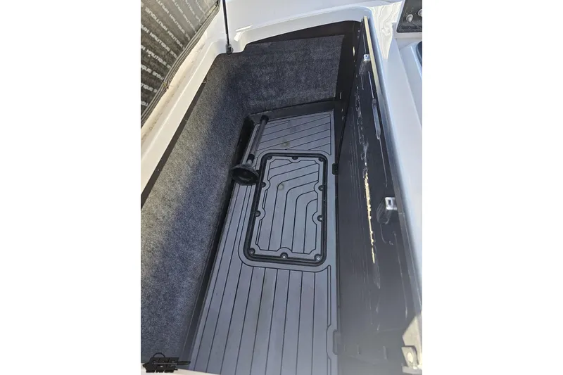 Slide: The Image of 2015 Nautique Super Air Nautique G23 storage compartment with black mat and gray interior. - 133
