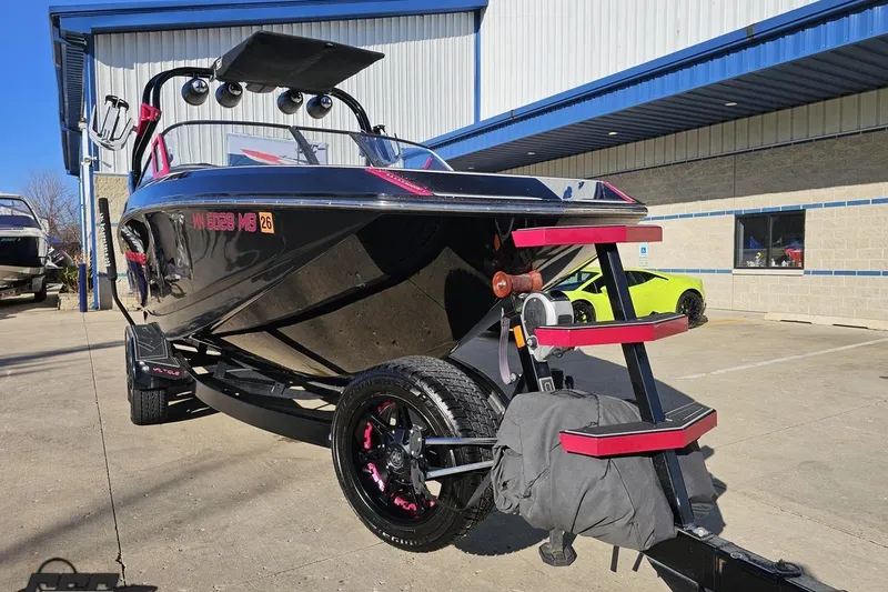Slide: The Image of 2015 Nautique Super Air Nautique G23 boat on trailer, parked outside a building. - 17
