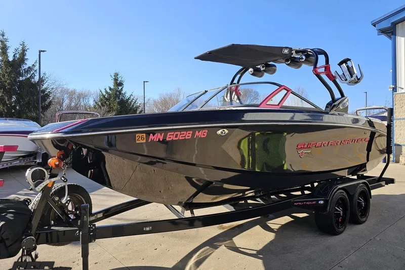 Slide: The Image of 2015 Nautique Super Air Nautique G23 boat on trailer, black exterior, parked outdoors. - 24