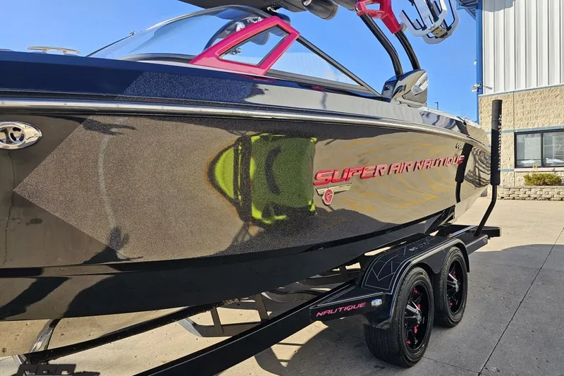 Slide: The Image of 2015 Nautique Super Air Nautique G23 boat on trailer, sleek black design. - 25