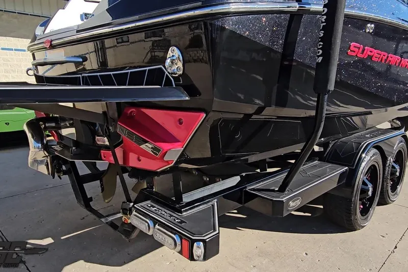 Slide: The Image of 2015 Nautique Super Air Nautique G23 boat on trailer, rear view, black and red design. - 40