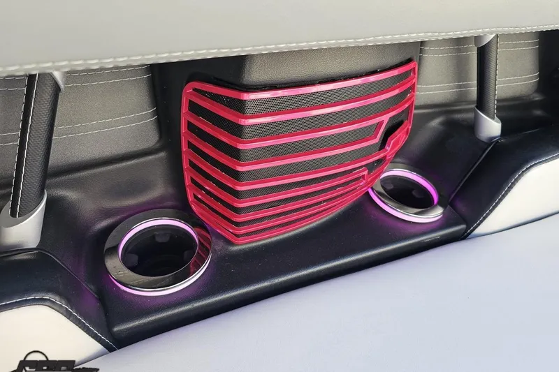 Slide: The Image of 2015 Nautique Super Air Nautique G23 interior with pink speaker grille and illuminated cup holders. - 71