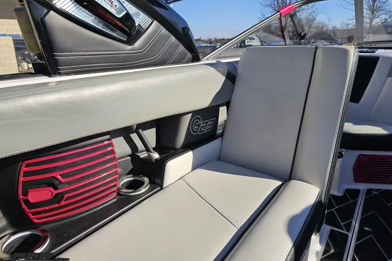 Slide: The Image of 2015 Nautique Super Air Nautique G23 interior with gray seating and red speaker accents. - 76
