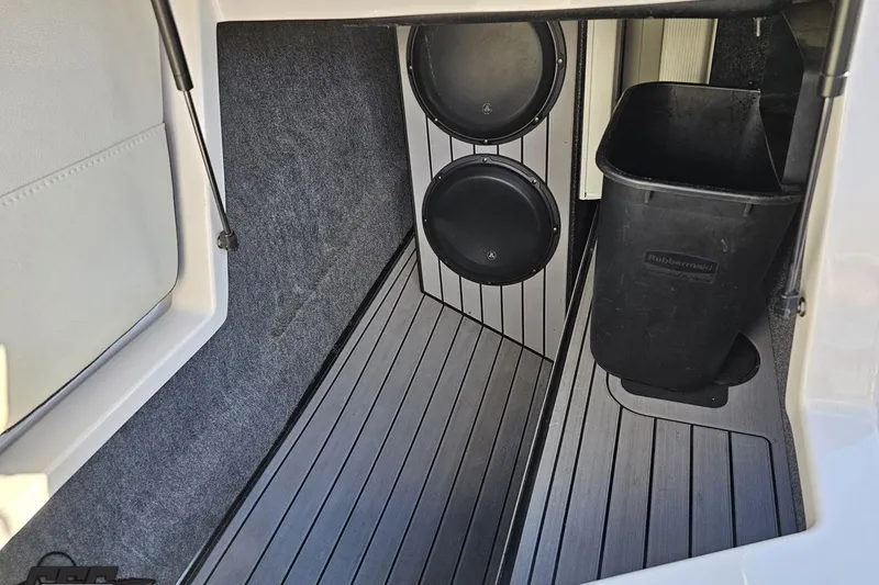 Slide: The Image of 2015 Nautique Super Air Nautique G23 interior with subwoofers and storage bin. - 81