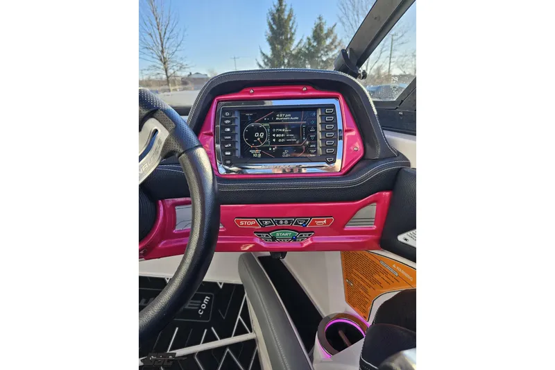 Slide: The Image of 2015 Nautique Super Air Nautique G23 dashboard with vibrant pink accents and digital display. - 88
