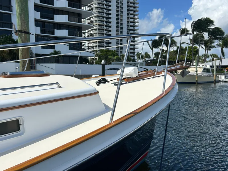 Slide: The Image of 1987 Lyman-Morse Downeast Flybridge boat docked near modern buildings and palm trees. - 18