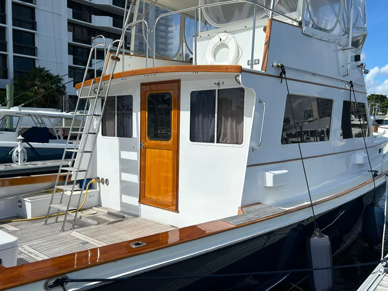 Slide: The Image of 1987 Lyman-Morse Downeast Flybridge yacht docked, featuring wooden accents and a flybridge. - 19