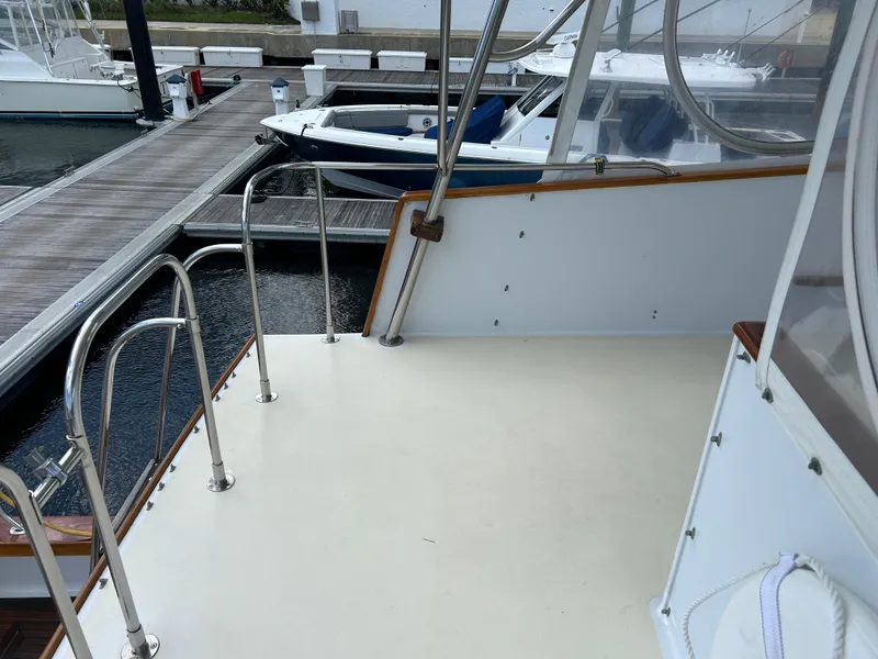 Slide: The Image of 1987 Lyman-Morse Downeast Flybridge boat docked, featuring a spacious deck and sturdy railings. - 29