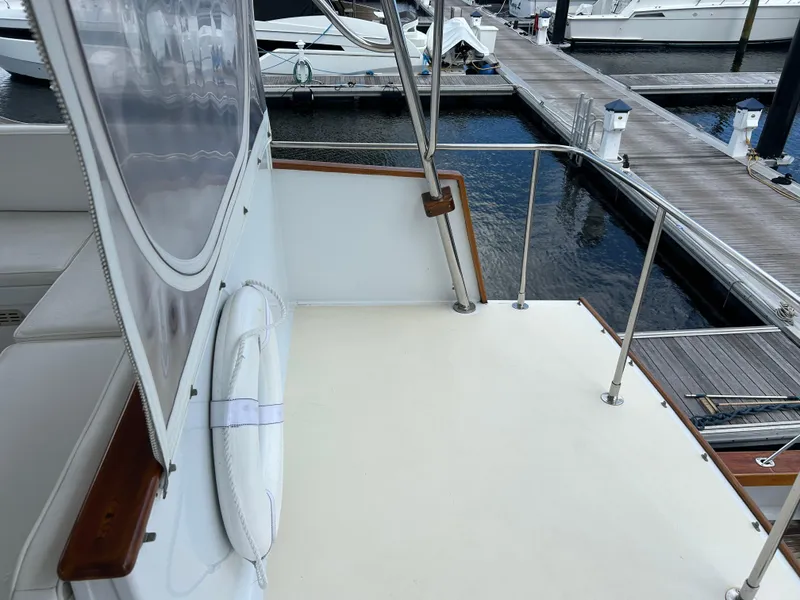 Slide: The Image of 1987 Lyman-Morse Downeast Flybridge yacht docked, featuring a clean deck and life preserver. - 30