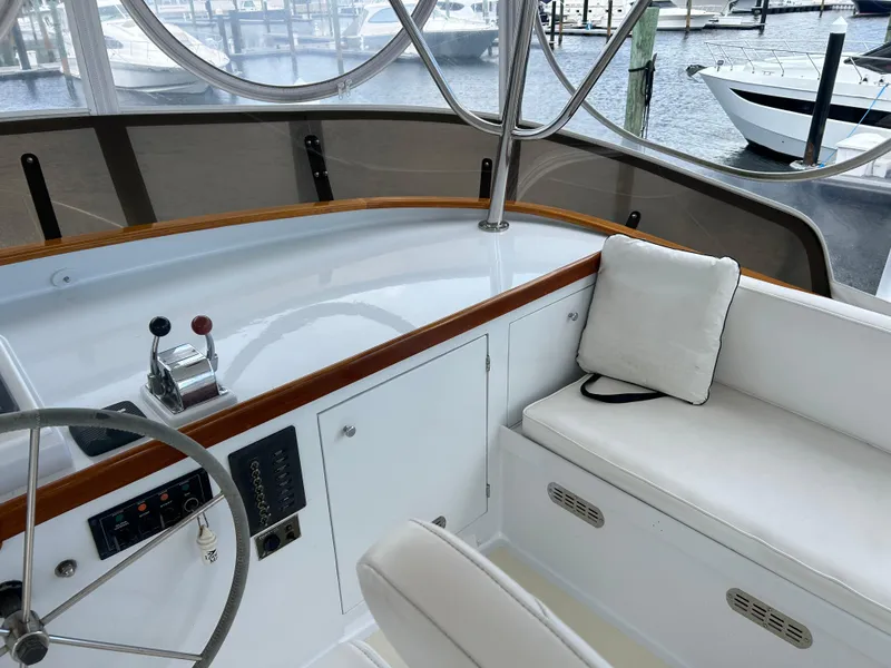 Slide: The Image of 1987 Lyman-Morse Downeast Flybridge interior with helm, seating, and marina view. - 35