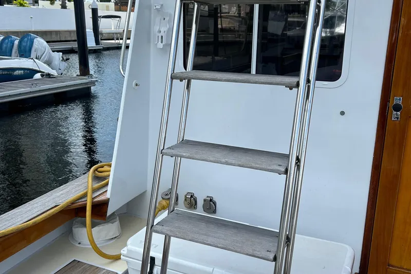 Slide: The Image of Lyman-Morse 1987 Downeast Flybridge boat ladder and deck area by the dock. - 37