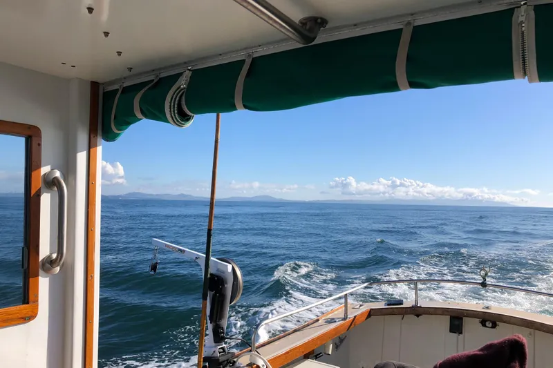 Slide: The Image of 1974 Dyer 29' Sport Fisher cruising on open sea under clear blue sky. - 10