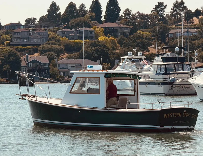 Slide: The Image of 1974 Dyer 29' Sport Fisher boat on calm water, surrounded by houses and other boats. - 2