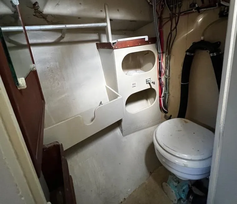 Slide: The Image of 1974 Dyer 29' Sport Fisher boat bathroom with toilet and storage shelves. - 31