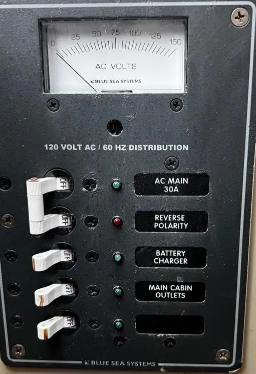 Slide: The Image of 1974 Dyer 29' Sport Fisher electrical panel with AC voltmeter and circuit breakers. - 33