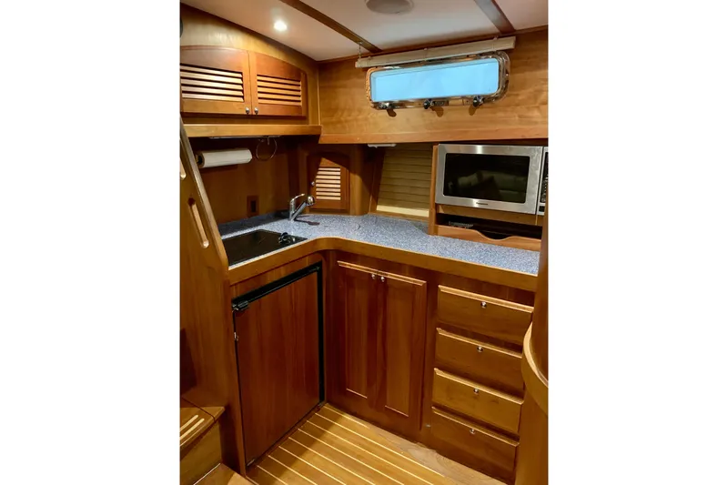 Slide: The Image of 2006 Sabre 38 Hard Top Express yacht interior with wooden cabinetry and modern appliances. - 15