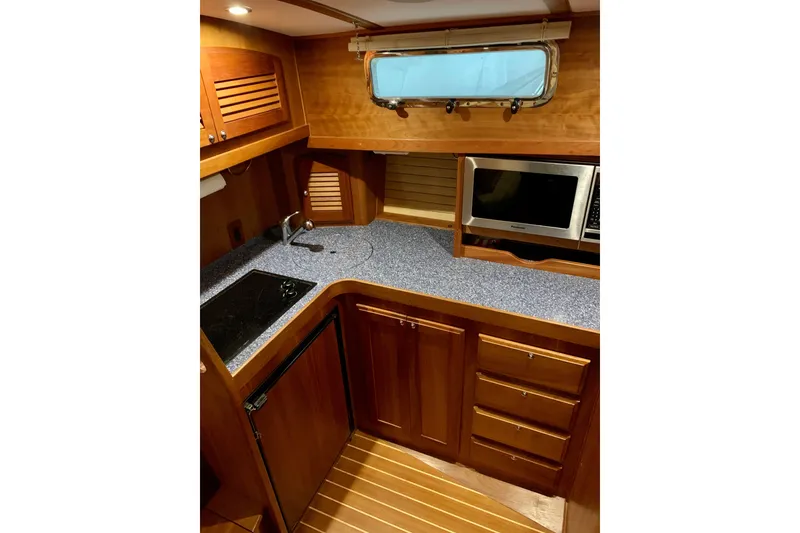 Slide: The Image of 2006 Sabre 38 Hard Top Express yacht kitchen with wood cabinetry and modern appliances. - 16