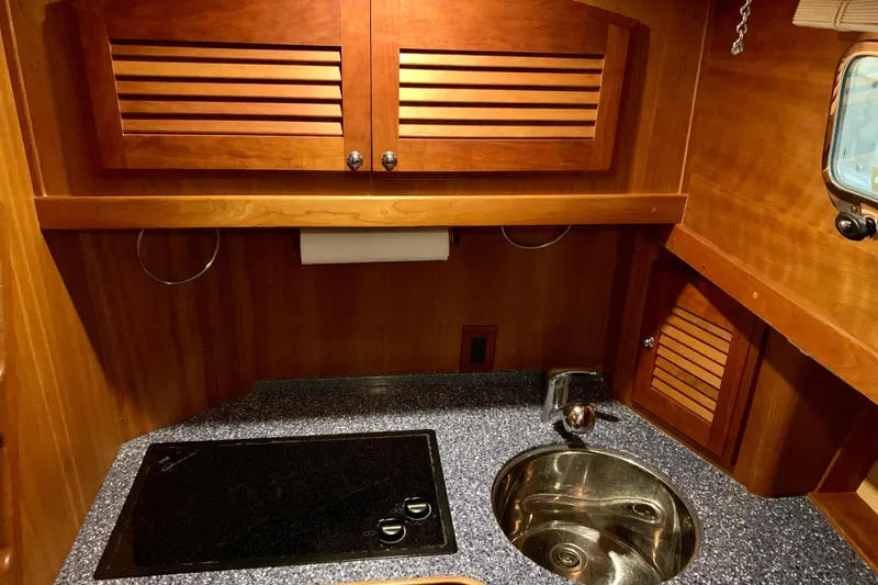Slide: The Image of 2006 Sabre 38 Hard Top Express yacht kitchen with wooden cabinets and modern sink. - 18