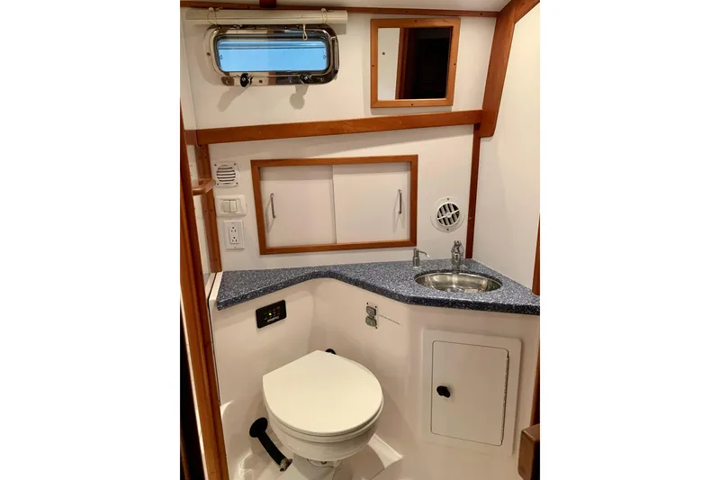 Slide: The Image of 2006 Sabre 38 Hard Top Express yacht bathroom with sink, toilet, and storage cabinets. - 21