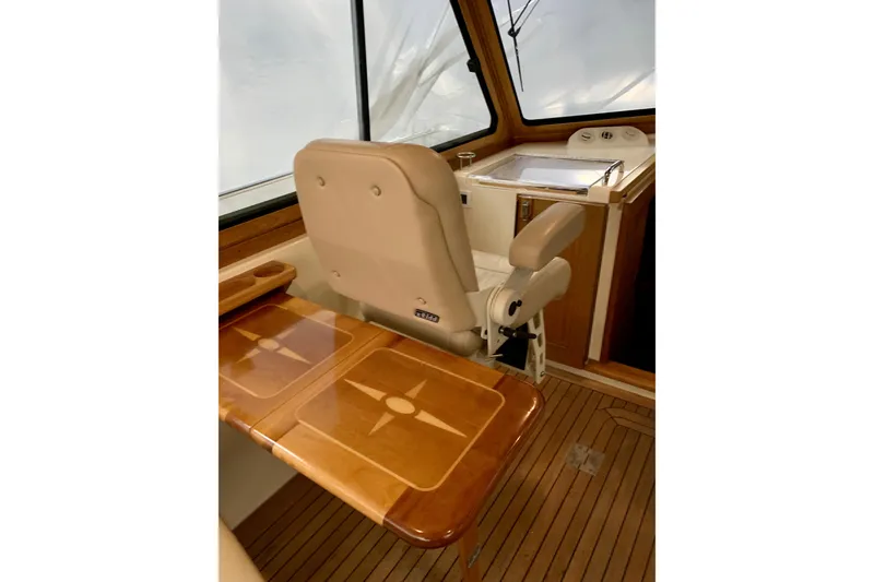 Slide: The Image of 2006 Sabre 38 Hard Top Express interior with helm seat and wooden table. - 37